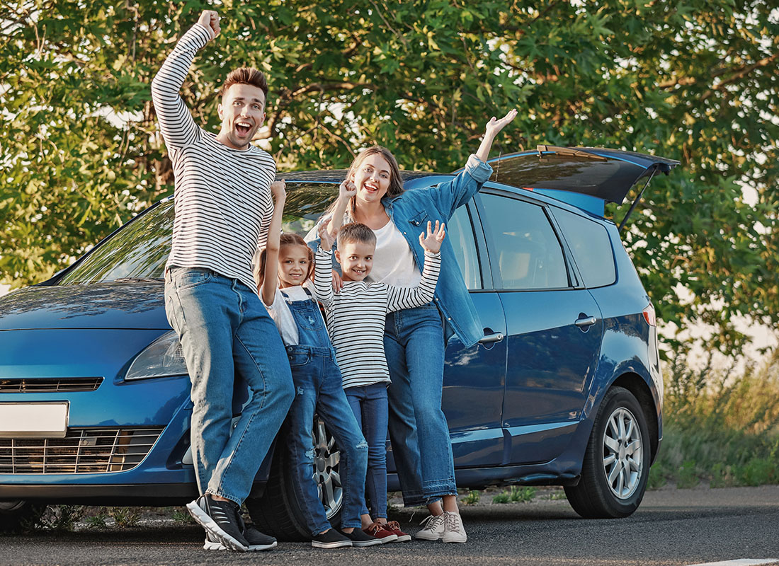 Personal Insurance - Happy Family Standing Next to Their Van While on a Road Trip